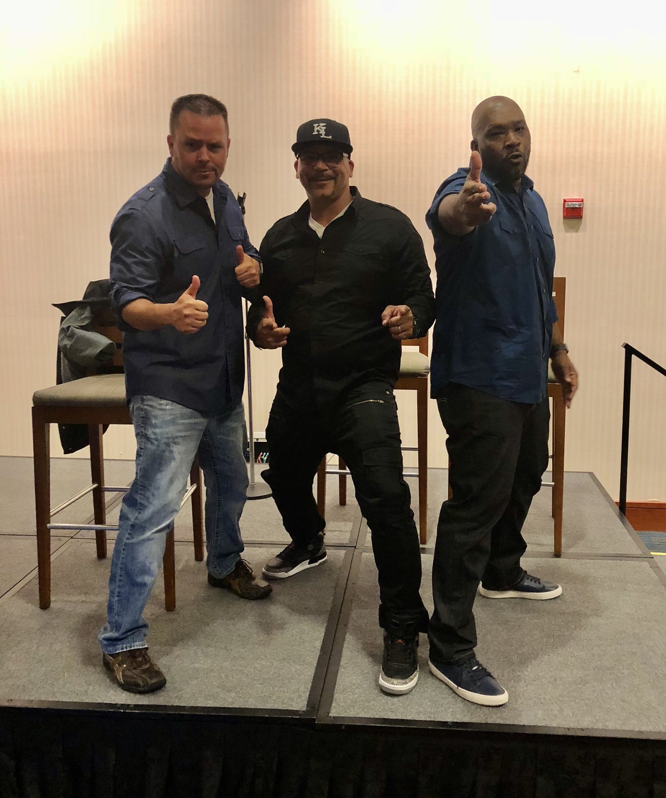 Jody Fuller giving a thumbs up on stage with two fellow entertainers at the Better Opportunities for Single Soldiers program in Leesburg, Virginia