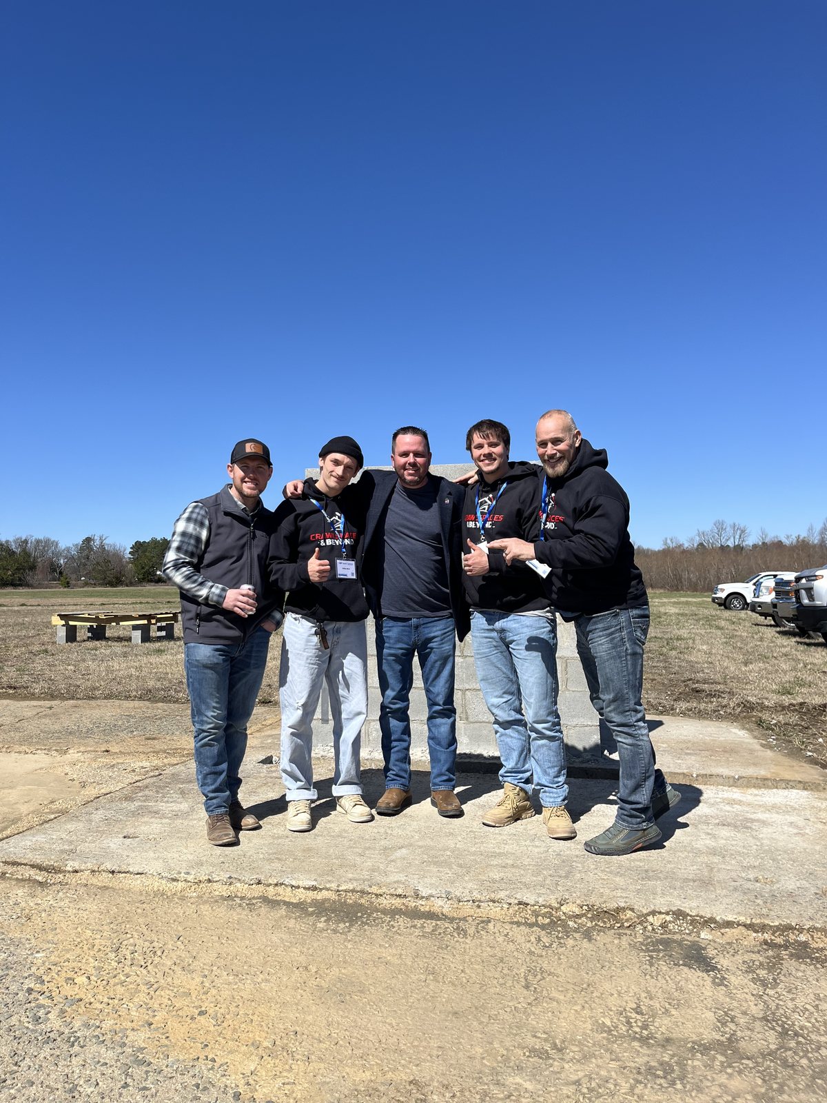Jody Fuller with contractors in Crawlspaces & Beyond hoodies at the Walder Foundation Products Contractor Field Day outdoor demonstration site in Ashland, Virginia