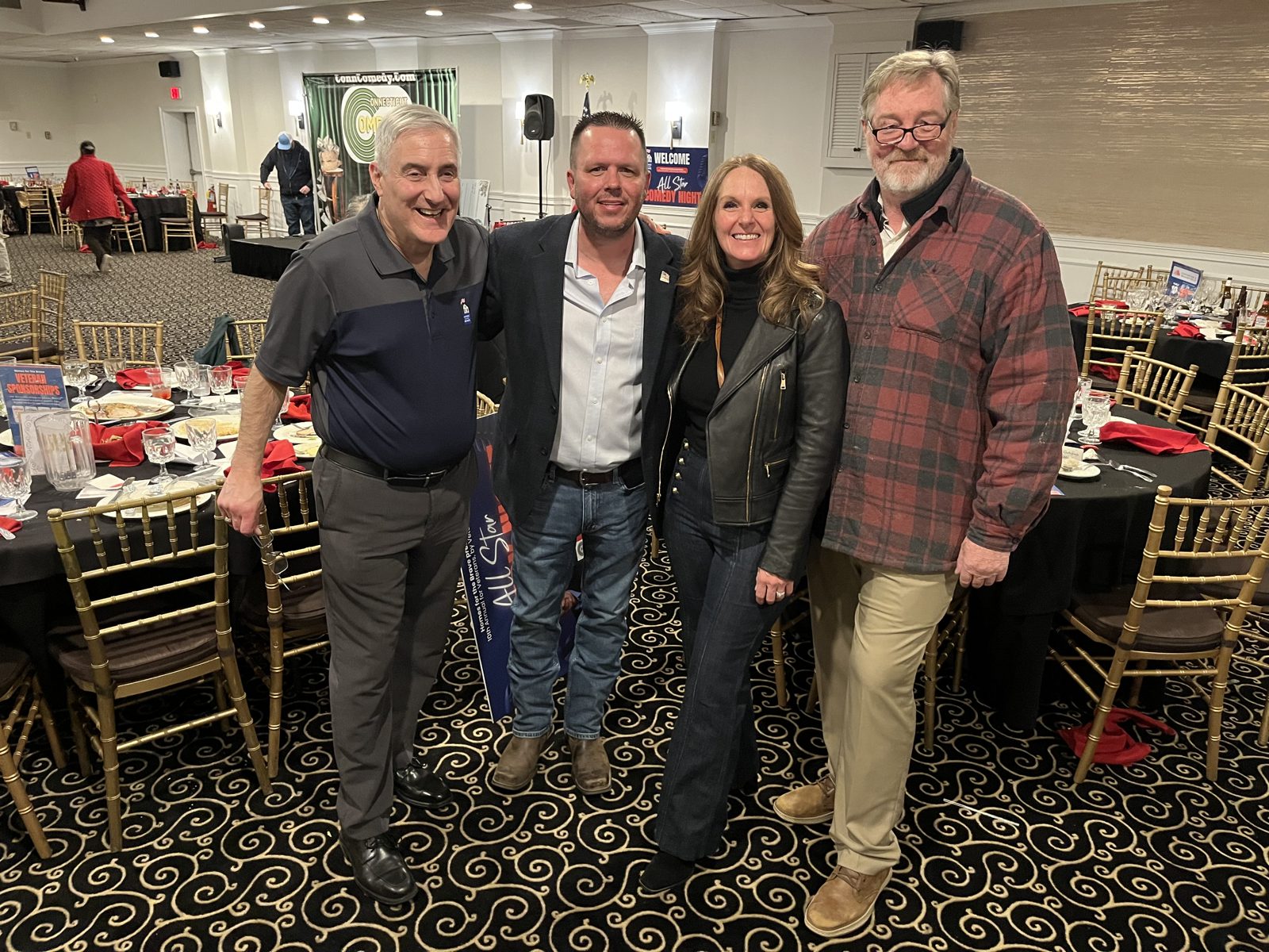 Jody Fuller with Homes for the Brave event hosts in the banquet ballroom at the 10th Annual veterans comedy night fundraiser